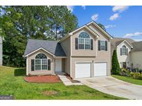 Charming two-story home with a two-car garage, lush lawn, and inviting curb appeal at 2635 Carolina Rdg, Riverdale, GA 30296