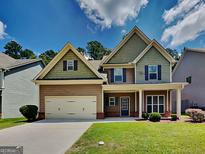 Charming two-story home with a well-manicured lawn, attached garage, and welcoming front porch at 513 Cherry Creek Dr, Loganville, GA 30052