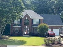 Charming two-story brick home with a well-manicured lawn and attached two-car garage at 1028 Gloria Grand Blvd, Mcdonough, GA 30252