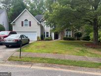 Charming two-story home with a well-manicured lawn, stone accents, and an attached two-car garage at 5327 Yoshino Ter, Powder Springs, GA 30127