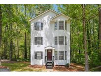 Charming three-story home with white siding, black shutters, and well-maintained landscaping at 4448 Janice Dr, Snellville, GA 30039