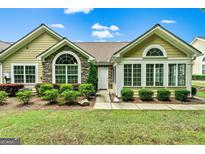 Charming home exterior featuring stone accents, many windows, and well-maintained landscaping at 140 Rehobeth Way, Fayetteville, GA 30214