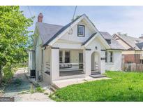 Charming white brick home with a welcoming front porch and lush green lawn at 975 Dill Sw Ave, Atlanta, GA 30310