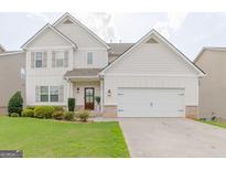 Charming two-story home with an attached two car garage and manicured lawn at 236 Villa Grande Dr, Locust Grove, GA 30248