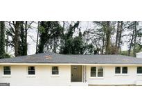 Charming single-story home with a gray roof, white painted brick, and neatly trimmed windows at 3994 E Hilda Cir, Decatur, GA 30032