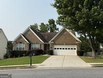 Charming brick home with a well-manicured lawn and a two-car garage at 1717 Prospect View Dr, Lawrenceville, GA 30043