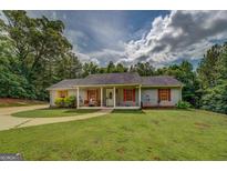 Charming single-story home features a well-manicured lawn and inviting covered front porch at 527 Malcom Rd, Covington, GA 30014