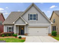 Charming home with a two-car garage, grey siding and manicured landscaping at 3018 Patriots Square, Marietta, GA 30064