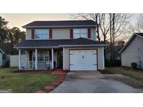 Charming two-story home features red accents, a front porch, and attached one-car garage at 1611 Cobbs Creek Ln, Decatur, GA 30032
