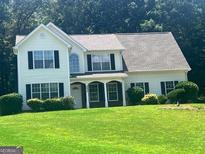 Charming two-story home with a well-manicured lawn and inviting curb appeal nestled among mature trees at 4489 Northwind Dr, Ellenwood, GA 30294