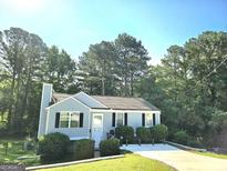 Charming single-story home featuring a manicured front yard, gray siding, and classic black shutters at 3253 Blackfoot Ln, Rex, GA 30273