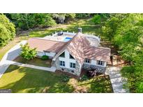 Spacious home featuring a swimming pool, stone accents, large lot and mature trees at 3222 Bay View Dr, Jonesboro, GA 30236