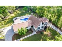 Stunning home showcasing backyard pool, lush landscaping, and stone elevation at 3222 Bay View Dr, Jonesboro, GA 30236