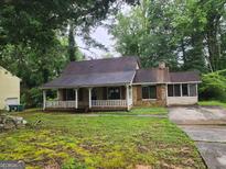 Charming single Gathering home with a covered front porch and stone accents at 6679 Cameron Rd, Morrow, GA 30260