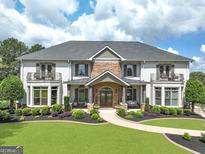 Stunning two-story home featuring a stone accent facade, double balconies, and professionally landscaped front yard at 30 Dorset Ct, Sharpsburg, GA 30277