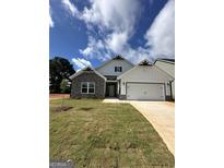 Charming two-story home featuring a stone facade and a well-manicured lawn with ample natural light at 11156 Cornerstone Way, Hampton, GA 30228
