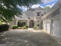 Charming brick home featuring a three-car garage and meticulously maintained landscaping in a suburban neighborhood at 103 Golf Terrace Dr, Stockbridge, GA 30281
