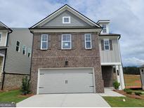 Charming two-story home features brick and siding exterior with an attached two-car garage at 37 Fraser Ln # 122B, Auburn, GA 30011