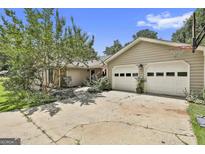 Traditional home boasts a two-car garage, lush landscaping, and a welcoming facade with trees in the front yard at 106 Lanyard Bnd, Peachtree City, GA 30269