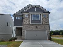 Two-story home showcasing gray brick, stone accents, gray siding, and a two-car garage at 38 Avian Way # 126B, Auburn, GA 30011