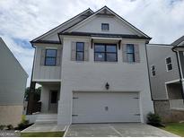 Charming two-story home featuring a painted brick facade, a two-car garage, and stylish shutters at 40 Avian Way # 127B, Auburn, GA 30011
