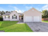 Charming single-story home with a well-maintained lawn and two-car garage at 11102 Hunters Ln, Hampton, GA 30228
