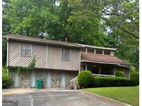 Charming multi-level home featuring a stone foundation, light brown siding, and a covered porch for relaxing outdoors at 4050 Daron Ct, Ellenwood, GA 30294