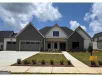 Charming single-story home boasts a manicured lawn, two-car garage, and inviting covered entry at 313 Ruffian Circle, Peachtree City, GA 30269