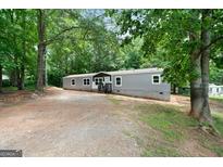 Exterior view of home with gray siding and wooded surroundings at 273 Ridge Dr, Villa Rica, GA 30180