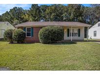 Charming single-story brick home with a well-maintained lawn and mature landscaping at 5575 Pine Gate Dr, Atlanta, GA 30349