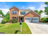 Charming brick home with a two-car garage, lush lawn, and well-maintained landscaping at 1777 Cutters Mill Way, Lithonia, GA 30058