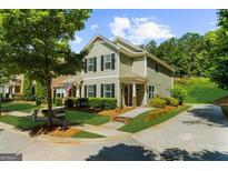Charming two-story home features a well-manicured lawn, complemented by lush trees and beautiful landscaping at 397 Cypher Dr, Suwanee, GA 30024