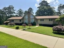 Charming single-Gathering home boasts a stone facade, well-manicured lawn, and mature trees at 115 Cannongate Cir, Sharpsburg, GA 30277
