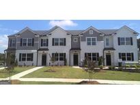 Charming townhomes boast a mix of gray and white exteriors, neat landscaping, and inviting curb appeal at 340 Sound Cir, Stockbridge, GA 30281