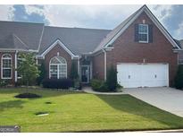 Charming brick home features a well-manicured lawn and a two-car garage, offering curb appeal at 333 Lauren Ln, Woodstock, GA 30188