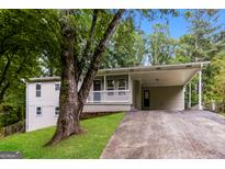 Charming single-Gathering home featuring a spacious carport, inviting front porch, and well-maintained landscaping at 64 Acorn Dr, Dallas, GA 30157