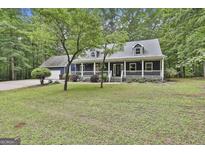 Charming home with a large, inviting front porch and well-manicured lawn surrounded by lush trees at 270 Carrolls Way, Fayetteville, GA 30215