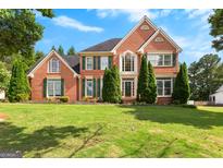 Beautiful two-story brick home with a well-manicured lawn and mature landscaping at 105 Roxbrough Ln, Fayetteville, GA 30215