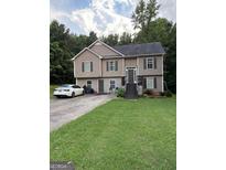 Inviting two-story home with neutral siding, well-maintained lawn, and paved driveway, perfect for suburban living at 120 Alfred Dr, Carrollton, GA 30116