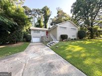 Charming brick home with a well-manicured lawn, stone accents and a red front door at 3456 Spring Cir, Decatur, GA 30032