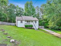 Charming, well-maintained home with a lovely front yard, inviting curb appeal, and a delightful covered porch at 394 Thornbrooke Dr, Hiram, GA 30141
