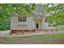 Charming home exterior with vinyl siding, mature trees, and well-maintained landscaping at 4135 Coursey Lake Rd, Douglasville, GA 30135