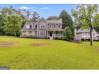 Charming two-story home with manicured lawn and mature trees in a desirable neighborhood at 90 Thomas Overby Dr, Sharpsburg, GA 30277