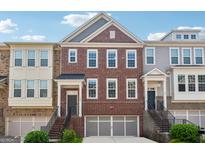 Charming townhome featuring a brick facade, attached garage, and welcoming entryways at 733 Wexford Cove Way, Mableton, GA 30126