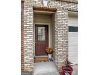 Charming front entrance with brick detail and welcoming door mat, creating an inviting entryway at 7177 Fringe Flower Dr, Austell, GA 30168
