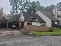 Charming townhome with a carport and quaint front yard, surrounded by mature trees in a quiet setting at 7 Willowick Dr, Lithonia, GA 30038