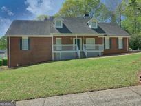 Charming brick home with a welcoming front porch and well-maintained lawn at 902 Sweetbay Ct, Stockbridge, GA 30281