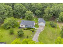 Expansive aerial view of home with large yard, mature trees, and detached garage at 3100 Meadow Trl, Loganville, GA 30052