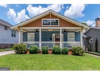Charming home featuring a cozy porch and well-manicured front yard with lush green lawn at 496 Rankin Ne St, Atlanta, GA 30308