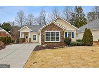 Charming one-story home featuring stone accents, a well-manicured lawn, and a welcoming front porch at 6775 Marlow Dr, Cumming, GA 30041